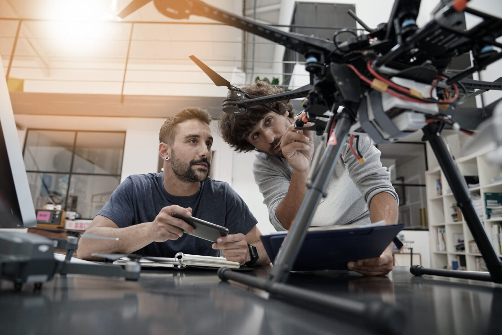 Engineer and technician working together on drone in office